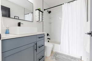 Full bath featuring vanity, shower / bathtub combination with curtain, and light wood finished floors