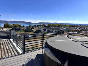 Wooden terrace with a residential view, a mountain view, and a hot tub