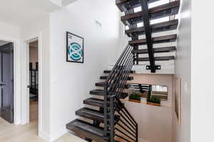 Staircase with baseboards and wood finished floors