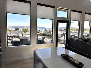 Kitchen with light stone counters, light wood-style floors, a mountain view, a residential view, and dark cabinetry