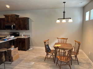 Dining space featuring light wood-type flooring and a textured ceiling