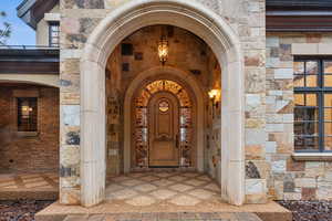 Entrance to property featuring stone siding and brick siding