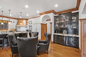 Dining area with light wood-type flooring, ornamental molding, and recessed lighting