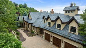 View of front of house featuring a high end roof, stucco siding, and stone siding