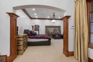 Bedroom with crown molding, arched walkways, light colored carpet, and recessed lighting