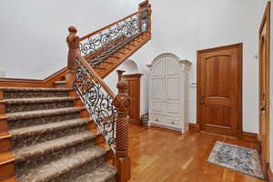 Staircase featuring wood finished floors and a high ceiling