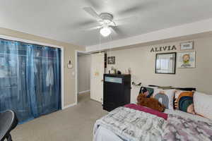 Bedroom with light colored carpet and a ceiling fan