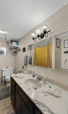 Bathroom featuring a textured ceiling and vanity
