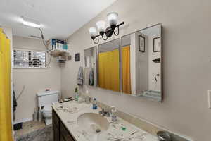 Bathroom featuring vanity, a textured ceiling, and a shower with shower curtain
