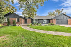 Ranch-style house featuring a front yard, a garage, brick siding, concrete driveway, and a shingled roof