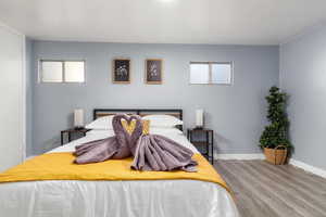 Bedroom featuring wood finished floors and multiple windows
