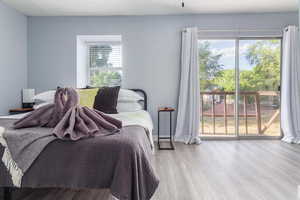 Bedroom with access to exterior and wood finished floors