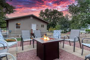 Patio terrace at dusk featuring a fire pit and a patio area