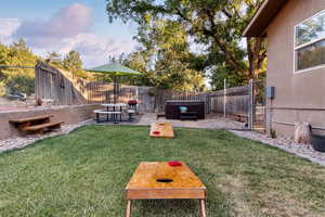 Fenced backyard featuring a hot tub and a patio area