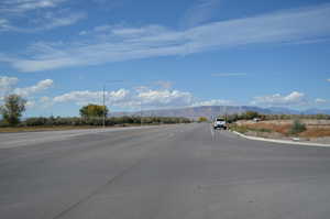 View of asphalt street featuring street lights and a mountain view
