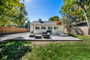 Back of house featuring a patio area, equipped for grill and hot tub, fire pit included.