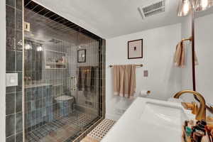 Bathroom with vanity, a stall shower with 2 shower heads, a textured ceiling, and tile patterned floors