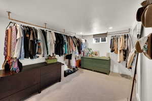 Downstairs bedroom currently used as oversized closet featuring carpet flooring