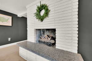 Detailed view of a brick fireplace and carpet flooring