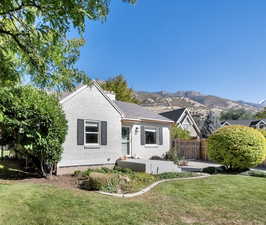 View of front facade with a chimney, a patio, brick siding, and a mountain view