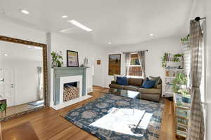 Living area featuring wood finished floors, recessed lighting, and a fireplace with flush hearth