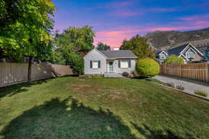 View of front of home featuring a fenced backyard, a chimney, and brick siding