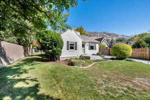 View of front of property with a fenced backyard, a chimney, a mountain view, and brick siding