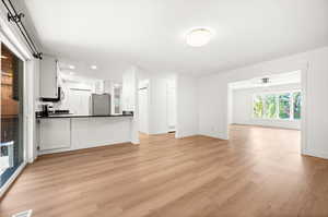 Unfurnished living room with light wood-style floors, a ceiling fan, and recessed lighting
