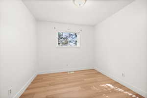 Empty room with light wood-type flooring and baseboards