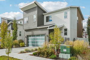 Contemporary home featuring driveway, a garage, and stucco siding