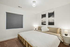 Bedroom featuring dark carpet and baseboards