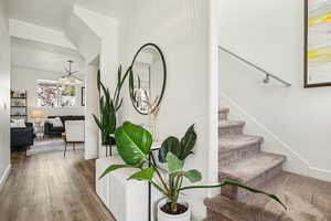 Stairway with wood finished floors and baseboards