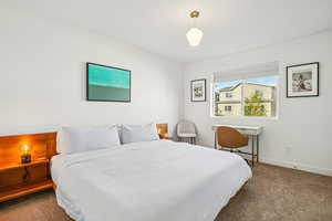 Bedroom with dark carpet and baseboards