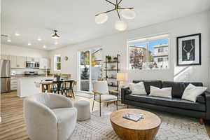 Living room featuring light wood-type flooring, recessed lighting, and a chandelier