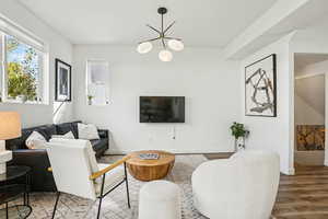 Living area with wood finished floors and a chandelier