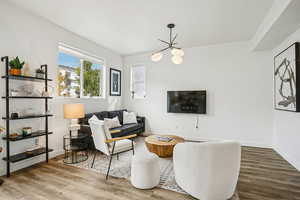 Living area featuring wood finished floors and a chandelier