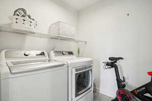 Washroom with washer and dryer and wood finished floors