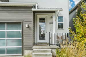 Doorway to property featuring a garage and stucco siding
