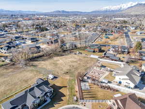 Aerial view of property and surrounding area with nearby suburban area and mountains