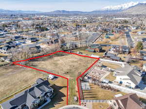 View of property location featuring nearby suburban area, mountains, and property parcel outlined