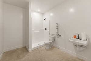 Bathroom featuring unfinished concrete floors, a stall shower, and recessed lighting