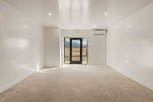 Empty room with unfinished concrete flooring and recessed lighting