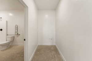 Corridor featuring concrete floors and baseboards