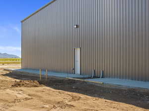 View of side of home with a mountain view and a pole building