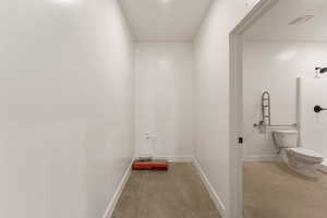 Laundry room with baseboards and concrete floors