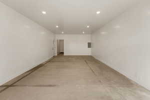 Empty room with concrete flooring and recessed lighting