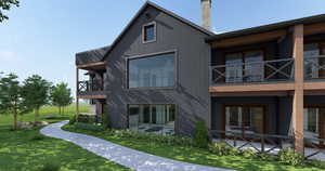 View of side of property with a balcony, a chimney, and a lawn