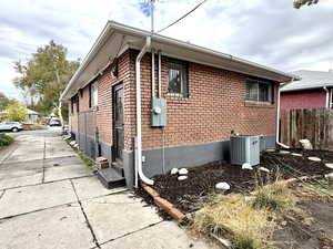 View of side of property featuring brick siding and a central air condition unit