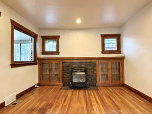 Unfurnished living room with a wood stove and light wood-style flooring
