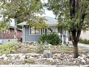 Bungalow-style home featuring roof with shingles and a porch